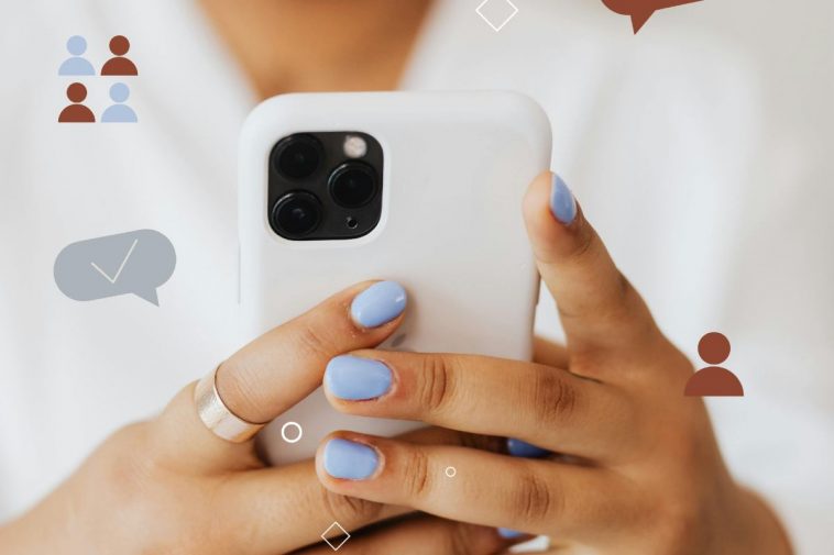 Uno smartphone bianco tra le mani di una ragazza