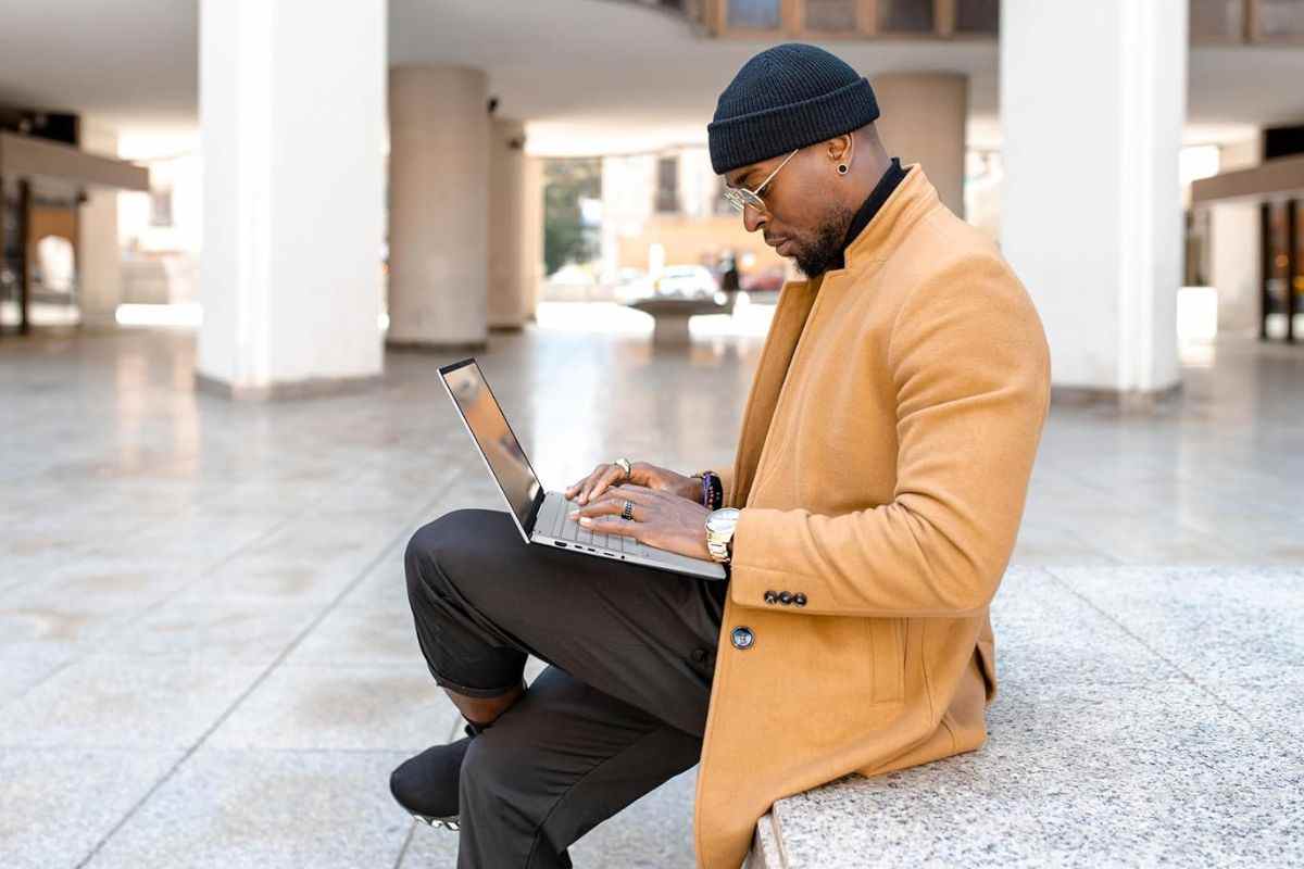 ragazzo su gradini all'esterno con asus in mano che scrive