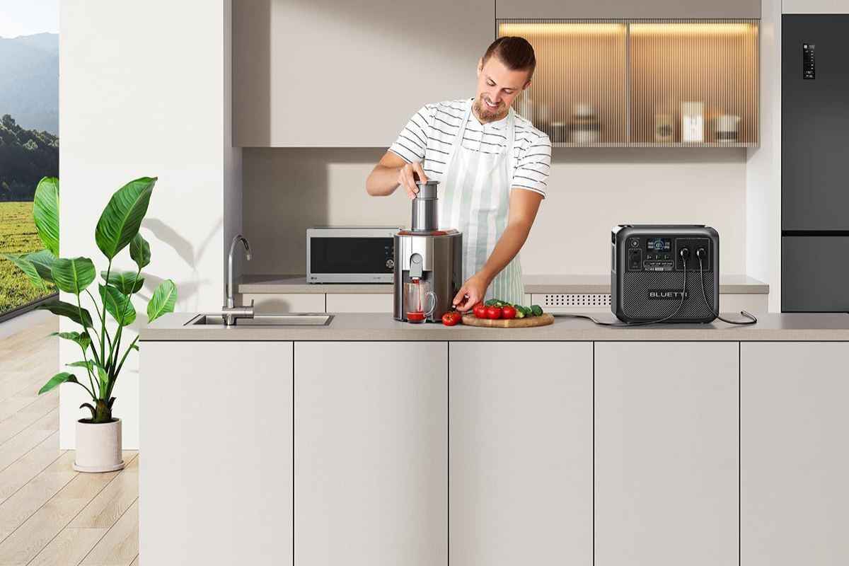 ragazzo in cucina con elettrodomestici e centrale elettrica protatile su bancone