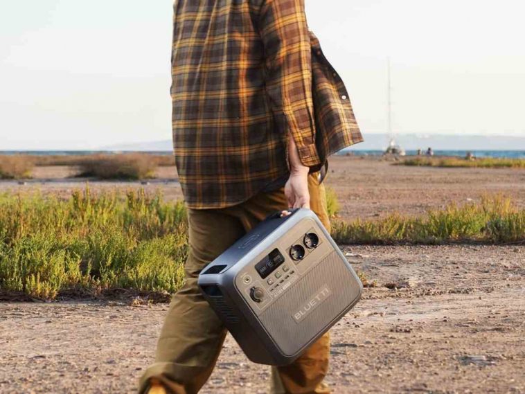 persona cammina nel bosco con centrale elettrca in mano