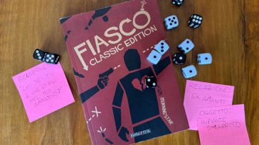 Manuale del GDR Fiasco circondato da dadi a 6 facce e post-it