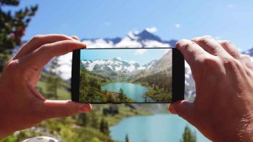 mani che fotografano un paesaggio