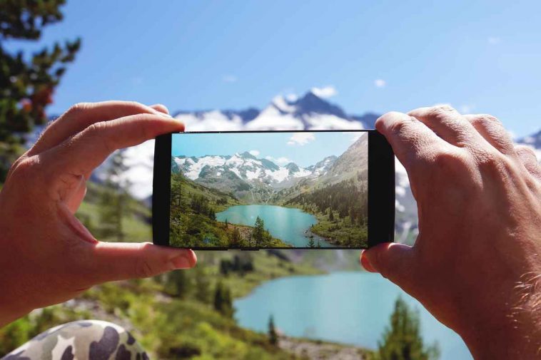 mani che fotografano un paesaggio