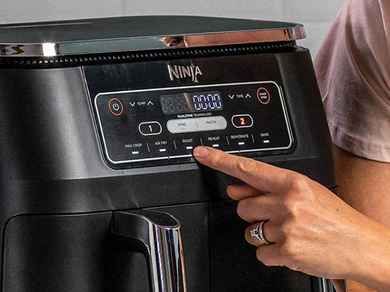 persona che clicca sui pulsanti della friggitrice ad aria dual zone ninja
