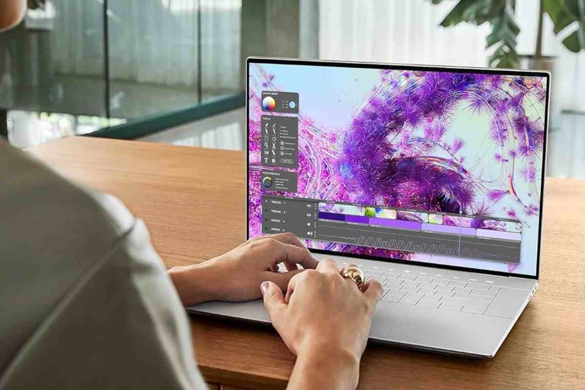 computer laptop con persona che lo utilizza sopra tavolo