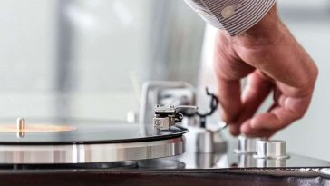 persona che sistema la puntina sul Giradischi Lenco