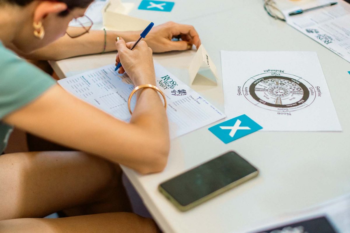 Una ragazza compila la scheda del suo personaggio durante una sessione del GDR Rosewood Abbey