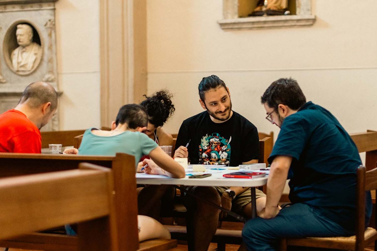 Gruppo di persone gioca al GDR Rosewood Abbey in una Chiesa.