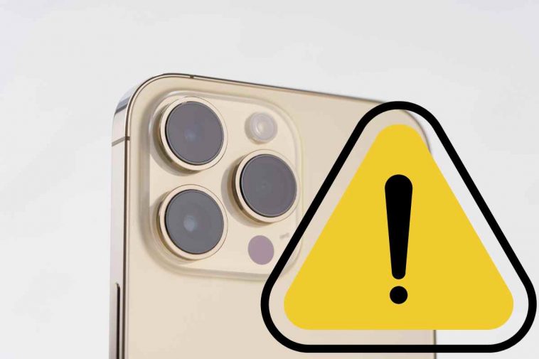 iphone dorato con segnale di pericolo