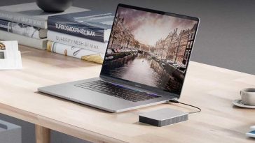hard disk esterno collegato a pc su scrivania con libri alle spalle