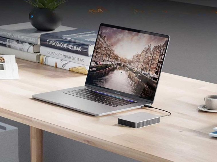 hard disk esterno collegato a pc su scrivania con libri alle spalle