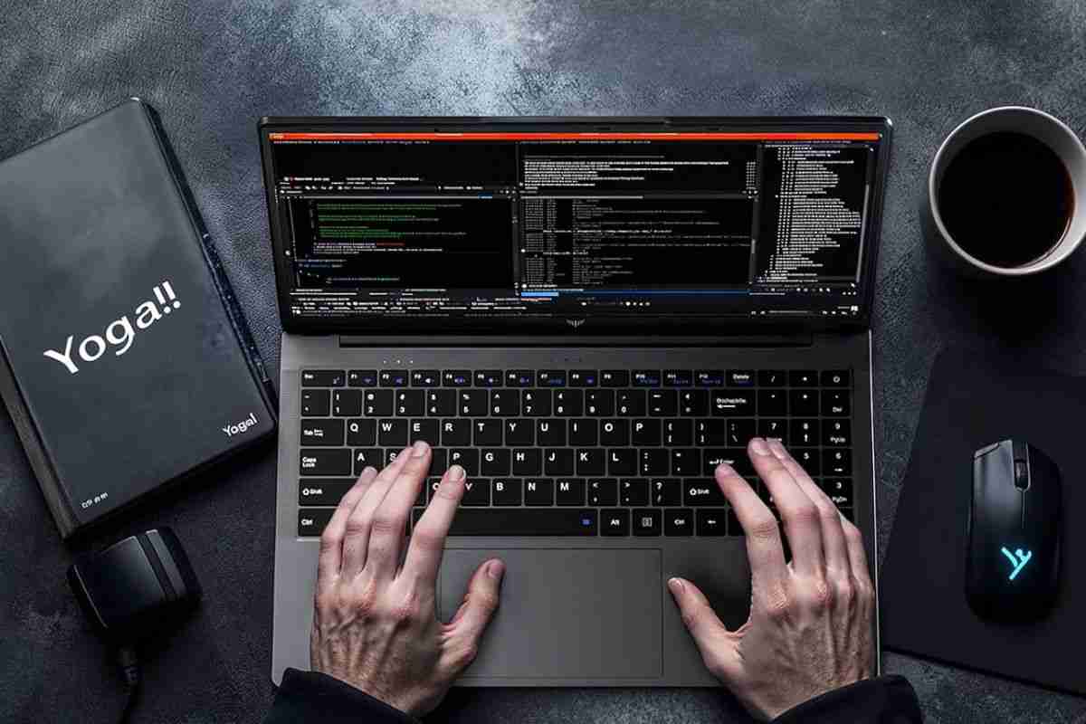 mani che digitano su laptop poggiato alla scrivania