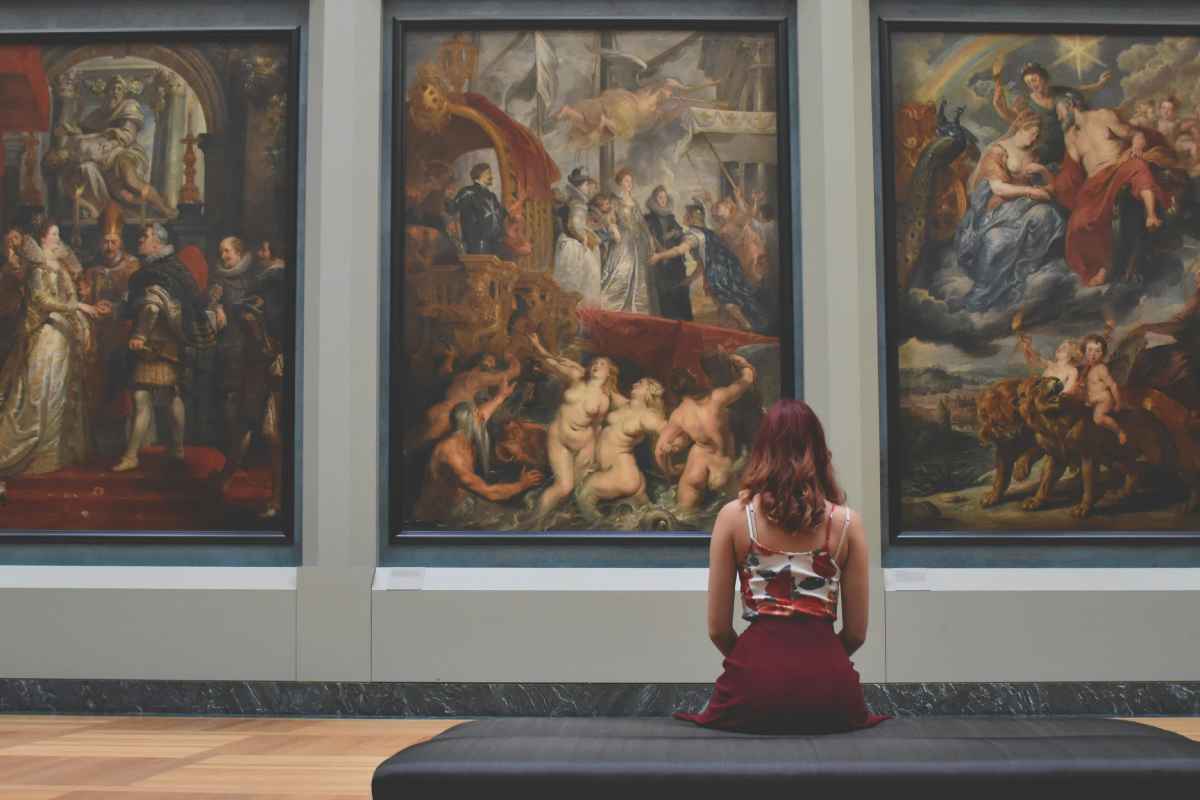 Una ragazza che ammira dei quadri in un museo