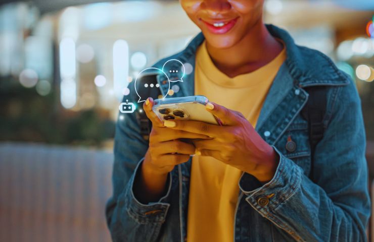 persona che ha in mano uno smartphone e lo usa per chattare con chatbot