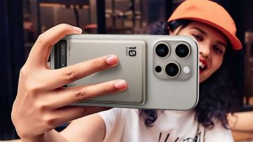 persona che tiene in mano uno smartphone con power bank magnetico attaccato dietro