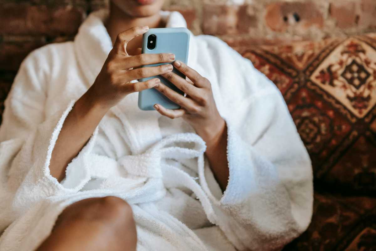 Ragazza in accappatoio che guarda un telefono