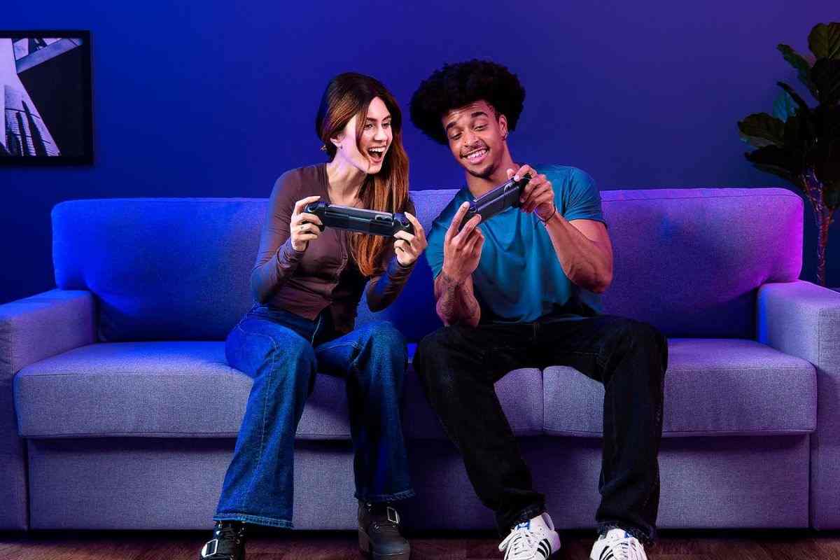 ragazzo e ragazza giocano con console portatile sul divano