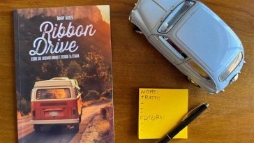 Manuale del GDR Ribbon drive di fianco il modellino di un'auto d'epoca e un post-it con dettagli di gioco trascritti sopra.