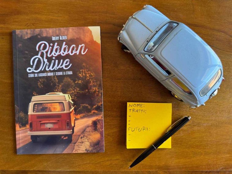 Manuale del GDR Ribbon drive di fianco il modellino di un'auto d'epoca e un post-it con dettagli di gioco trascritti sopra.