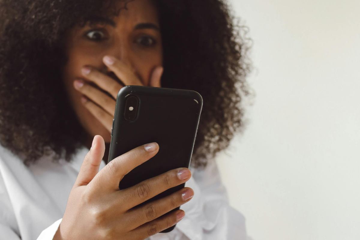 Una ragazza che guarda lo smartphone e si sorprende