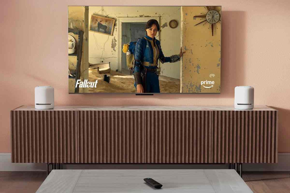 televisione con serie Fallout appesa al muro, su tavolnetto telecomando fire stick