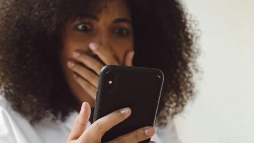 Ragazza sconvolta che guarda il telefono