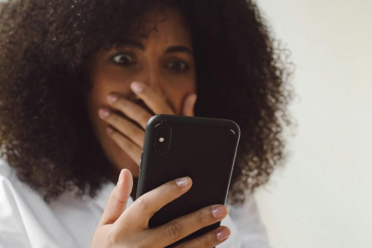 Ragazza sconvolta che guarda il telefono
