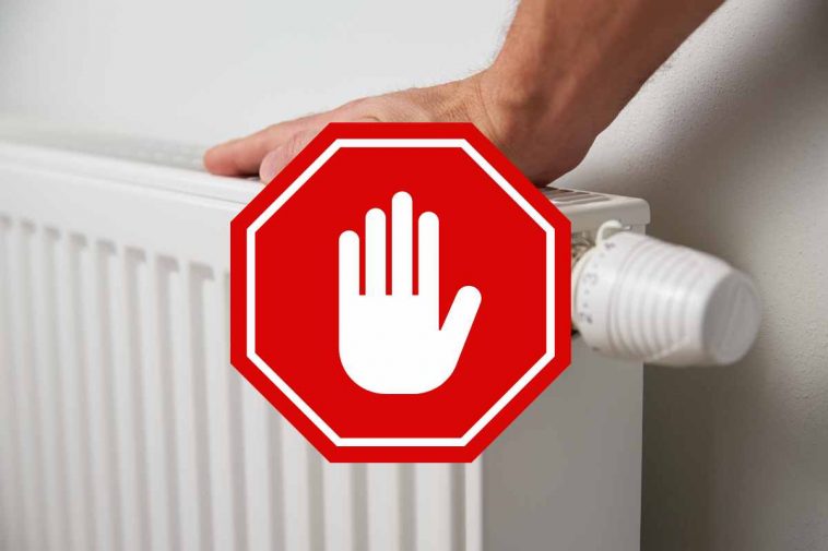 mano su un termosifone bianco