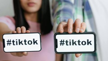 Due ragazzi mostrano i telefoni con la scritta TikTok