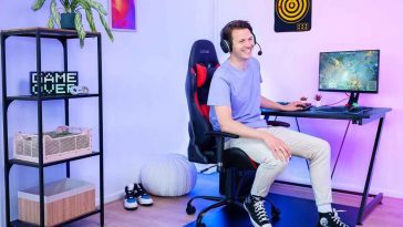 ragazzo seduto su sedia da gaming davanti a scrivania con computer