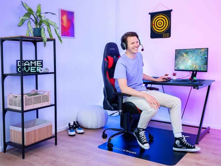 ragazzo seduto su sedia da gaming davanti a scrivania con computer