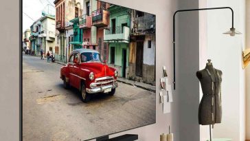 smart tv LG OLED evo AI C5 appesa alla parete con un'auto rossa sul display