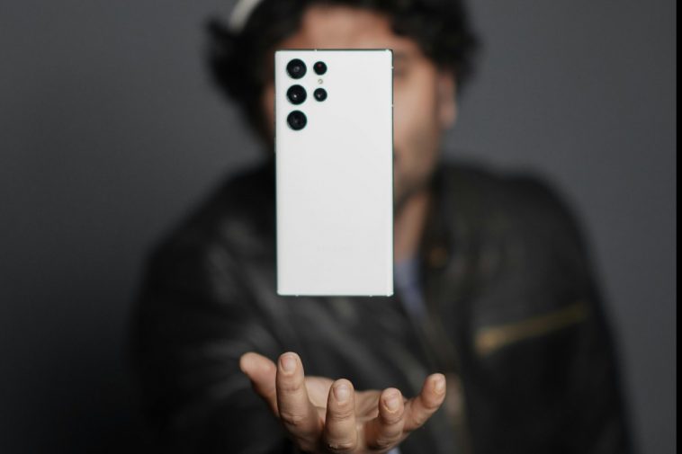 Un ragazzo che fa lievitare dalla mano aperta un Samsung bianco