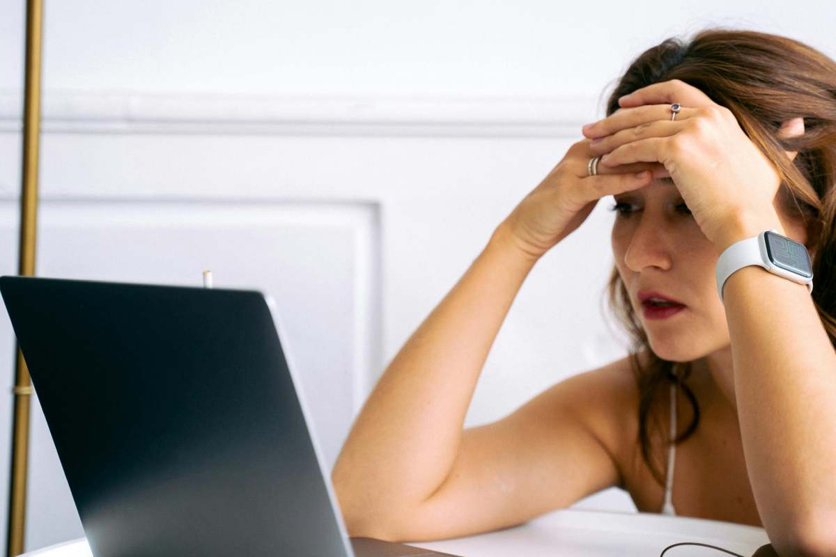 Una ragazza sconfortata di fronte alla schermo di un portatile