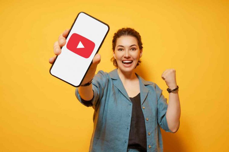 donna mostra telefono con logo youtube