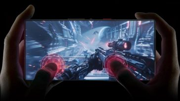 REDMAGIC 10SPro 12G+256G Nightfall tenuto in mano da persona, con pollici poggati su schermo, immagine di fucile