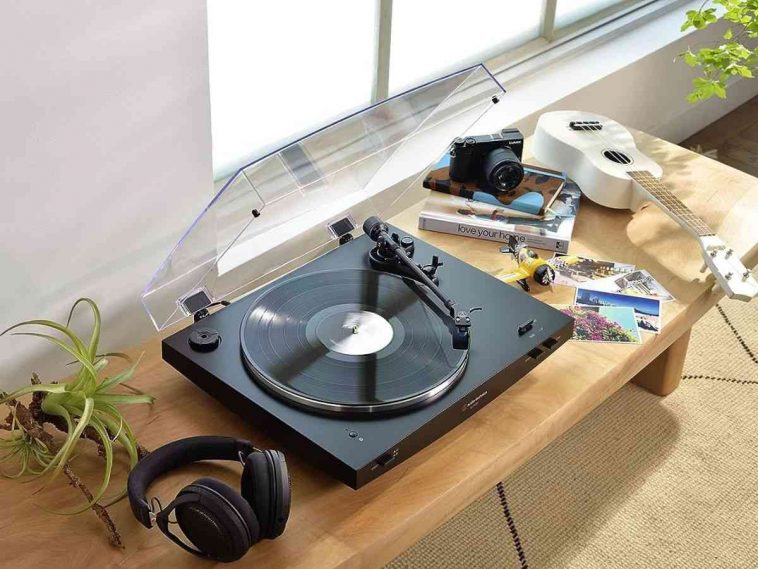 giradischi audio technica sulla scrivania con cuffie e altri accessori