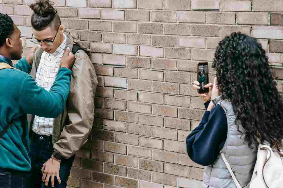 Una ragazzina filma con un telefono un atto di bullismo