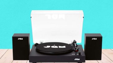 jam giradischi appoggiato a un tavolo di legno e dietro parete verde