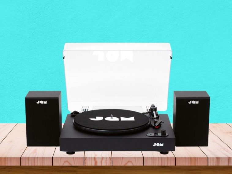 jam giradischi appoggiato a un tavolo di legno e dietro parete verde