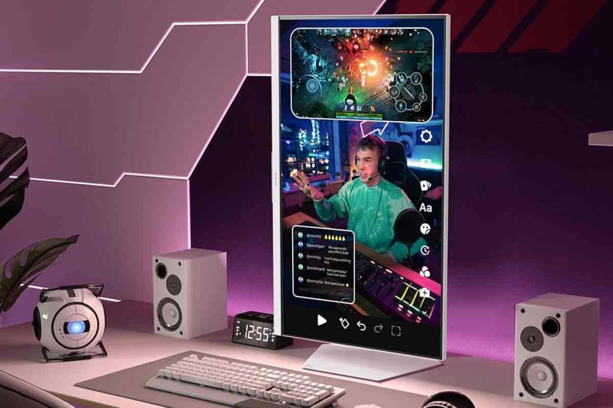 monitor da gaming posizioanto in verticale sopra scrivania con tastiera, mouse e speaker, sullo schermo immagine ragazzo con cuffie