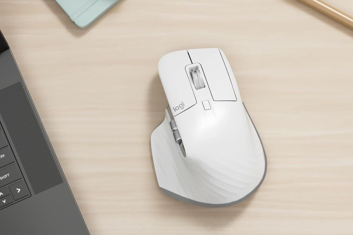 mouse logitech bianco su scrivania in legno accanto a tastiera PC
