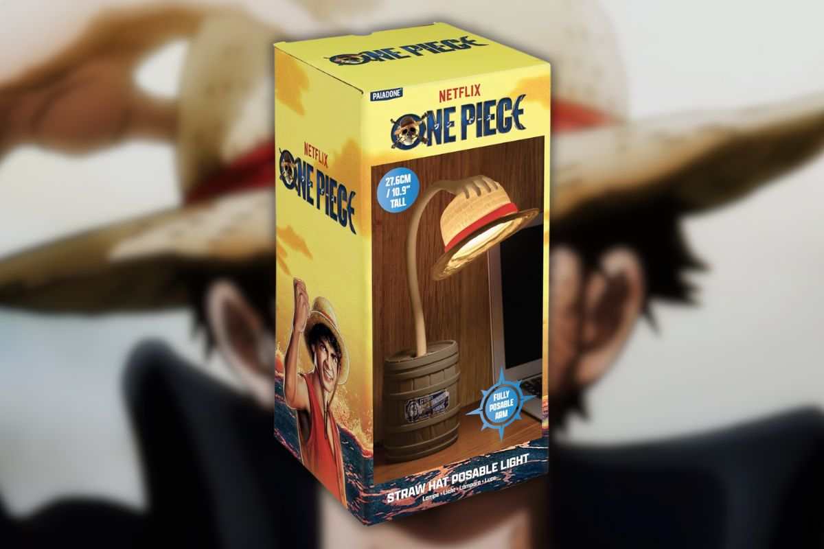 lampada a forma di braccio che regge cappello di paglia che esce da barile all'interno di scatola, su sfondo personaggio disegnato con cappello di paglia