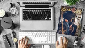 Un portatile su una scrivania ingombra di oggetti