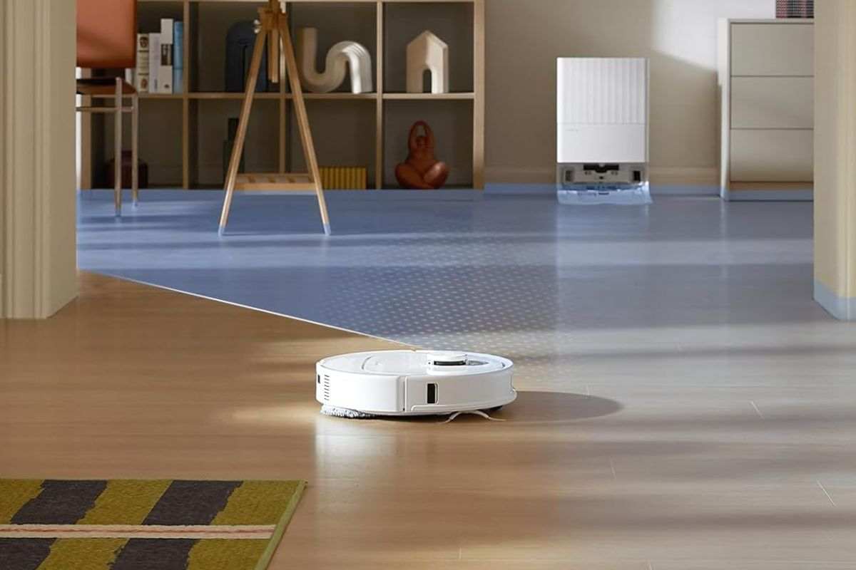 robto aspirapolvere bianco che cammina su parquet in salotto