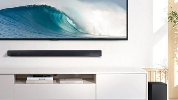 soundbar sopra mobile bianco, sotto televisione a muro