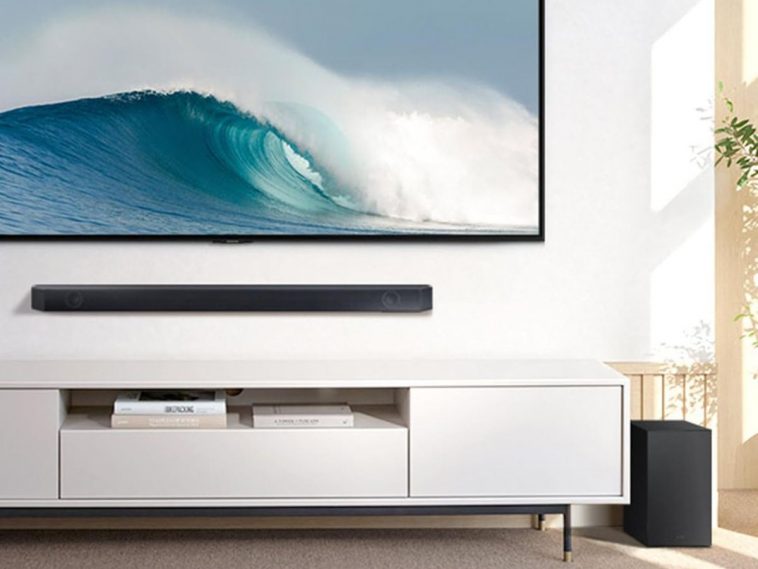 soundbar sopra mobile bianco, sotto televisione a muro