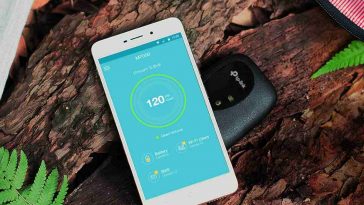 wifi portatile tplink appoggiato a terra dietro uno smartphone