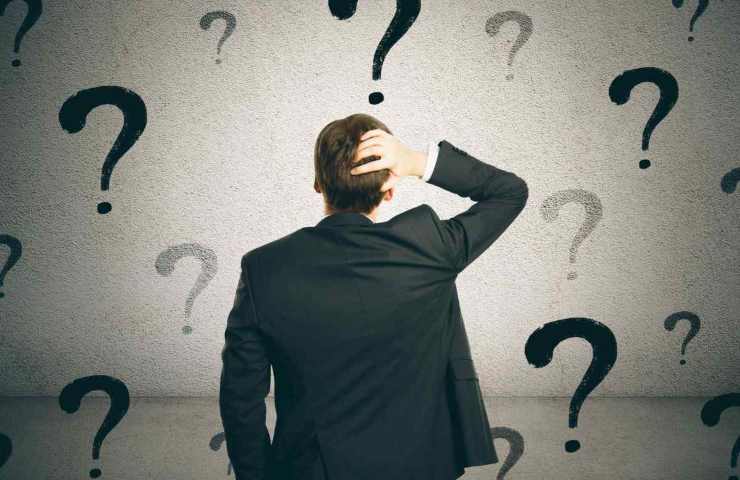 uomo pieno di punti interrogativi