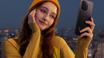 ragazza con maglione giallo, cappello giallo e xiaomi POCO in mano